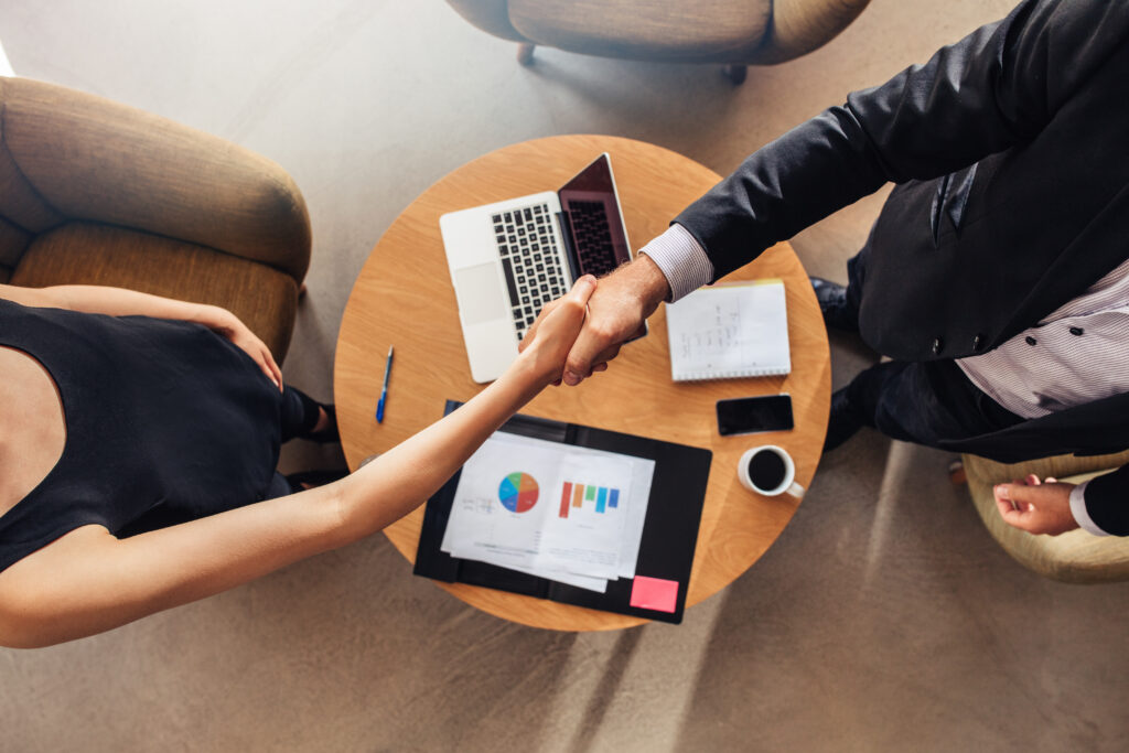 Two business professionals shaking hands after a closed deal.