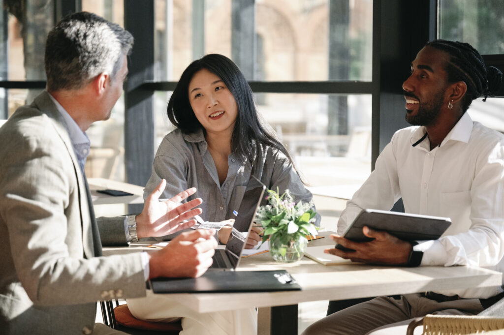 Three business professionals engaged in a discussion in a cozy workplace environment.